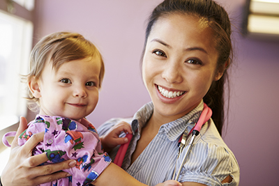 Young Girl Being Held By Female Pediatric Doctor